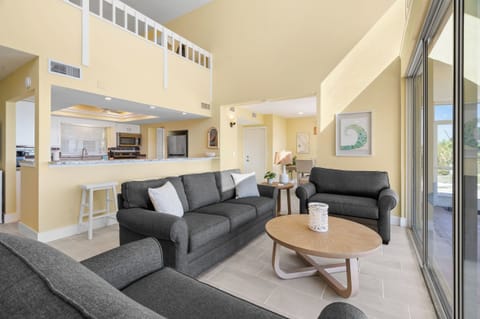 Relax in your spacious living room with comfortable seating, open kitchen views, and bright natural light streaming through sliding doors.