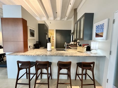 A kitchen with stools and a counter top.