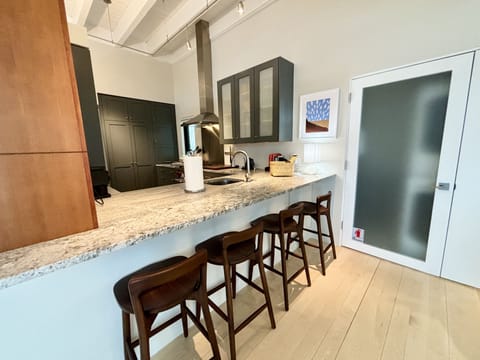 A kitchen with a bar and stools.