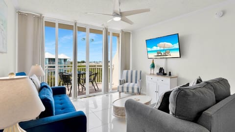 Step into your bright, airy living room with coastal charm. Relax on plush seating as you enjoy peaceful views from your private balcony, where gentle breezes and blue skies await.