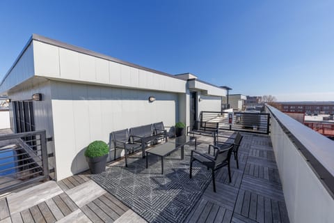 Rooftop deck w/ lounge seating & open sky views, perfect for sunny afternoons