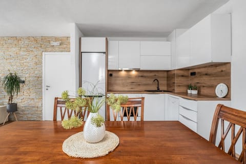 Dining table, living room with very comfortable sofa, a TV and a balcony with pool views