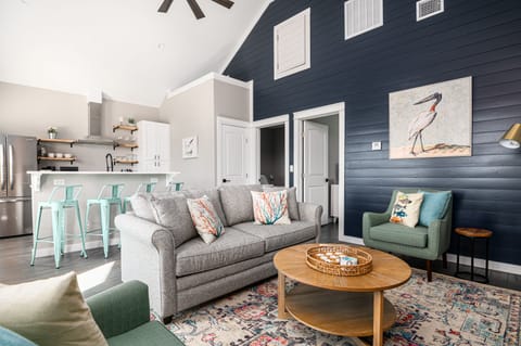Living space with queen sofa, two arm chairs, games, beach towels, ceiling fans