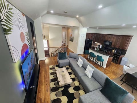 Spacious living room with sectional sofa, large TV, and warm lighting