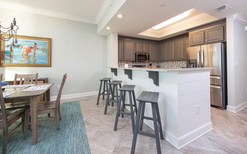 Sip coffee at the bar and admire the charcoal cabinets in this inviting kitchen space