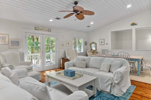 Bright living room with white slipcovered sofas and a coastal dining area