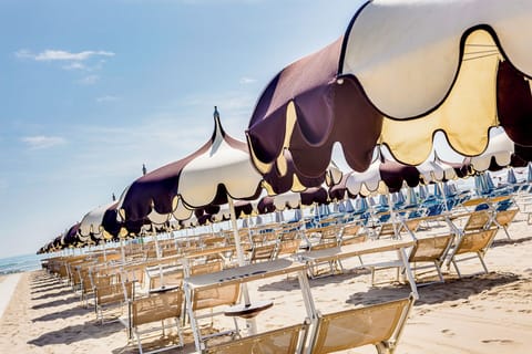 On the beach, white sand, sun loungers, beach umbrellas