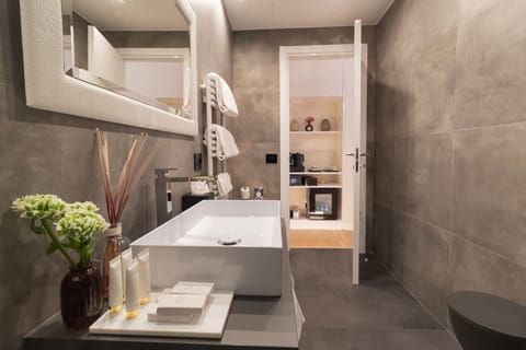 Deluxe Suite, City View | Bathroom | Rainfall showerhead, designer toiletries, hair dryer, slippers