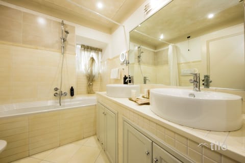 Deluxe Suite, City View | Bathroom | Designer toiletries, hair dryer, bathrobes, slippers