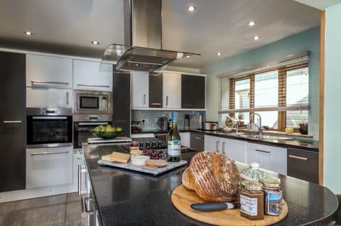 Deluxe House | Private kitchen | Full-size fridge, microwave, toaster, highchair