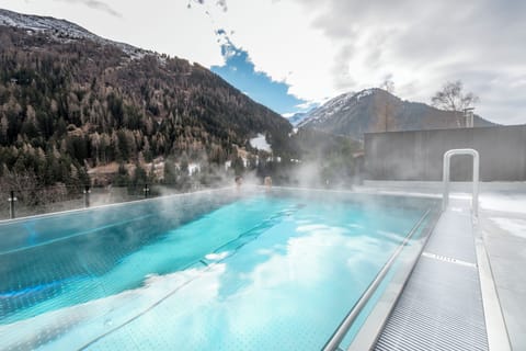 Outdoor pool, an infinity pool, pool umbrellas, sun loungers