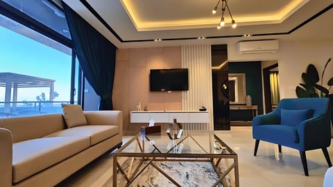 Deluxe Apartment, 3 Bedrooms | Living area | 32-inch flat-screen TV with cable channels