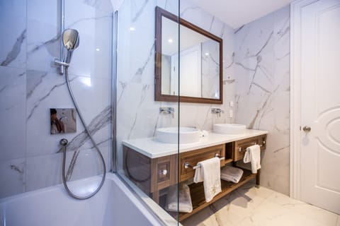 Bathtub, designer toiletries, hair dryer, bathrobes