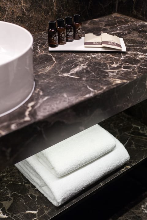 Deluxe Room | Bathroom | Designer toiletries, hair dryer, slippers, towels