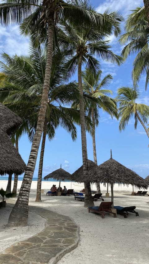 On the beach, white sand, sun loungers, beach umbrellas