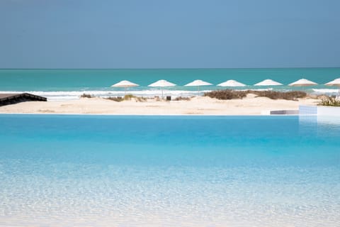 On the beach, white sand, sun loungers, beach umbrellas