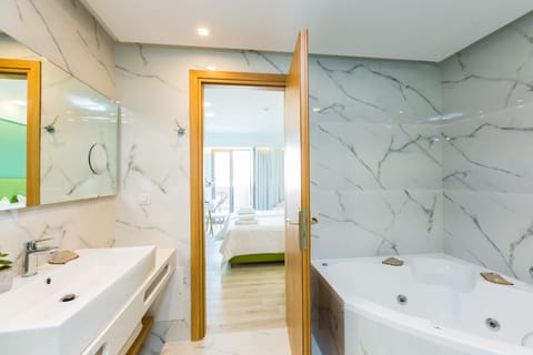 Deluxe Studio Suite, Jetted Tub | Living area | 26-inch flat-screen TV with cable channels, TV, books