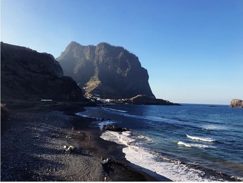 On the beach, black sand, 2 beach bars, surfing