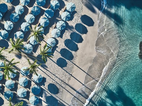 On the beach, white sand, beach cabanas, sun loungers