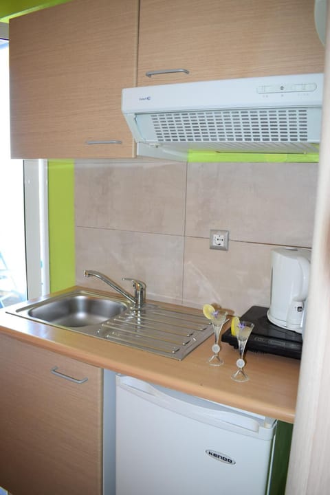 Full-size fridge, stovetop, electric kettle, cookware/dishes/utensils