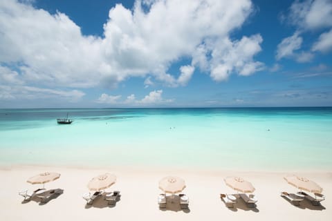 On the beach, white sand, sun loungers, beach umbrellas