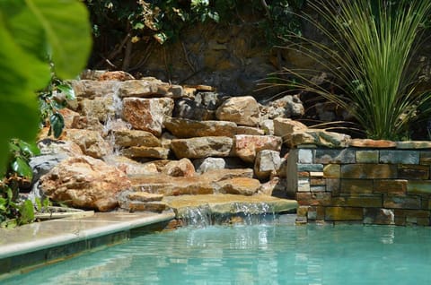 Outdoor pool, a waterfall pool, open 9:30 AM to 7:00 PM, pool umbrellas
