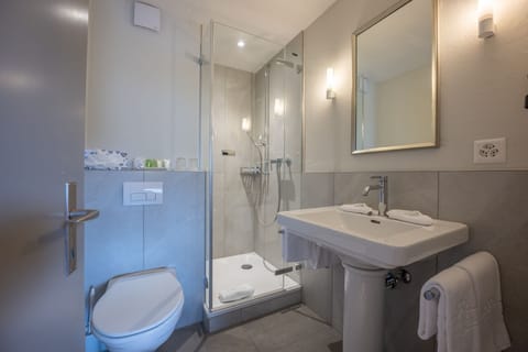 Suite Eiger View | Bathroom | Combined shower/tub, eco-friendly toiletries, hair dryer, bathrobes