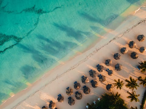 On the beach, white sand, sun loungers, beach umbrellas