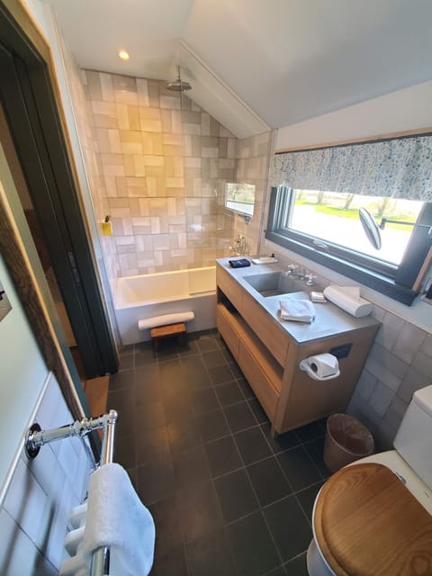 Deluxe Suite | Bathroom | Deep soaking tub, rainfall showerhead, free toiletries, bathrobes