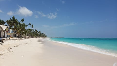 On the beach, white sand, sun loungers, beach umbrellas