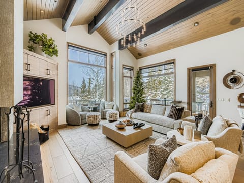 Relax in your spacious living room featuring vaulted wood ceilings, a cozy fireplace, and comfortable seating areas perfect for unwinding after your mountain adventures.