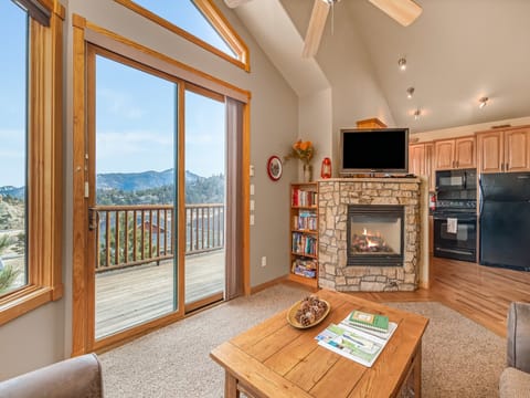 Teepee Mountain 12A - a SkyRun RMNP Property - Teepee Mountain 12A  - Open concept between living room and kitchen with a fireplace and flat screen TV. With beautiful view from the deck.
