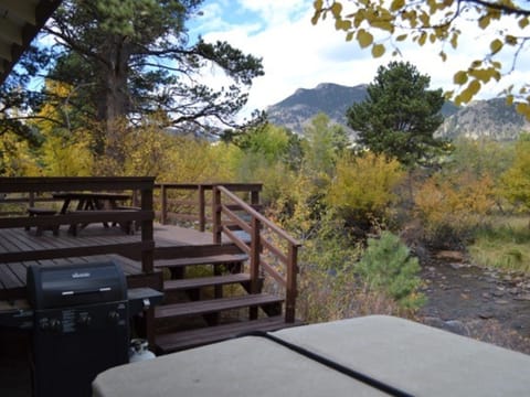 Murphy's Riverside Cottage -- 20-NCD0227 - a SkyRun RMNP Property - Murphy's River Cottage - Deck features a BBQ grill and picnic table for outdoor dining during the summer months