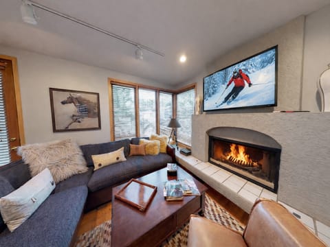 Cozy up in your stylish living room where a crackling fireplace meets modern comfort. Perfect for après-ski relaxation with plush seating and entertainment.