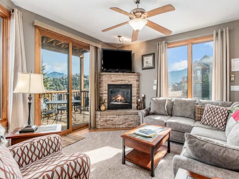 Mount Cirrus 10B - a SkyRun RMNP Property - Mount Cirrus 10B - Large living room with oversized chair and L shaped sofa. Flat screen TV with gas fireplace and panoramic views out the sliding glass doors.