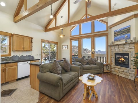 Jackstraw Mountain 32 - Take in breathtaking mountain views from the floor to ceiling windows in main living area. This space boasts vaulted ceilings, a beautiful stone gas fireplace, and two comfortable double-cushion sofas.