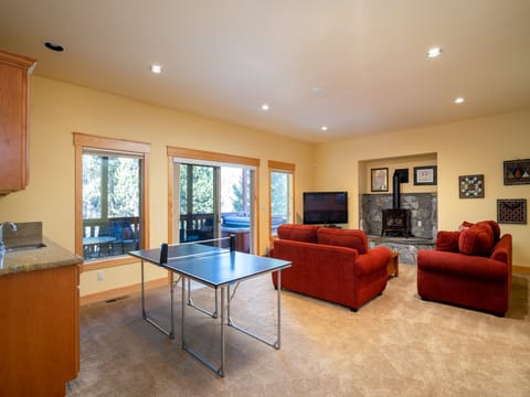 Showcasing the family room's charm with direct access to the covered deck featuring a hot tub.
