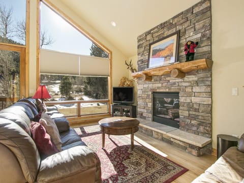 Tranquility on the River Four -- 20-NCD0366 - a SkyRun RMNP Property - Tranquility on the River Four - Large open living with plenty of comfy seating for all, floor to ceiling windows with a river view, and cozy gas fireplace.