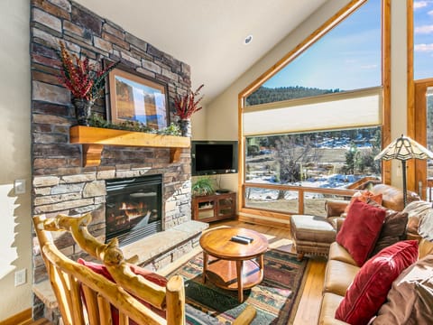 Tranquility on the River Three -- 20-NCD0365 - a SkyRun RMNP Property - Tranquility on the River Three - Large open living with plenty of comfy seating for all, floor to ceiling windows with a river view, and cozy gas fireplace.