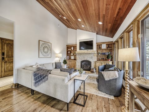 Gather with loved ones in this inviting living room, where soaring wood-beamed ceilings and a cozy stone fireplace create the perfect retreat after your mountain adventures.