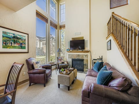 Unwind in your bright, airy living room with soaring ceilings, a cozy fireplace, and comfortable seating—perfect for relaxing after a day of adventure.