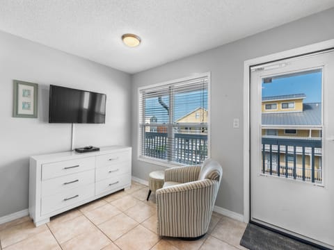 Entry to Unit 305 opens to the living area, which offers comfortable seating, and a mounted television.