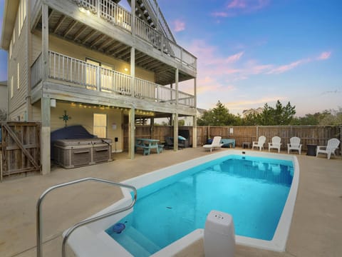 Pool and Hot Tub on left side of house at sunset.