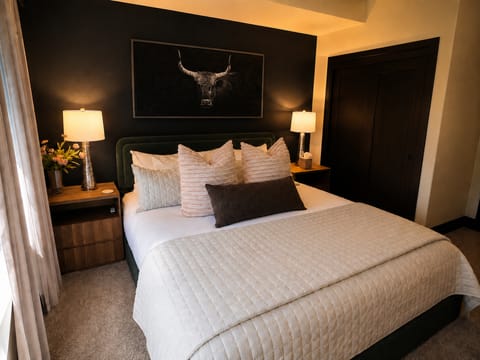 Your cozy bedroom awaits with a plush bed dressed in soft linens and stylish pillows. Warm lighting creates a peaceful ambiance while modern touches add comfort to your retreat.