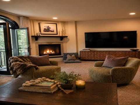 Unwind in your cozy living space, where plush seating and a crackling fireplace invite you to relax. Soft textures and warm lighting create the perfect retreat after a day exploring.