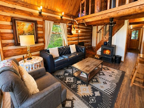 Sink into plush sofas by your crackling fireplace in this stunning log cabin retreat, where rustic charm meets modern comfort.