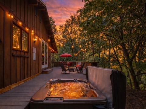 Soak in your private hot tub as golden sunset light filters through the trees, creating the perfect evening retreat on your secluded deck.
