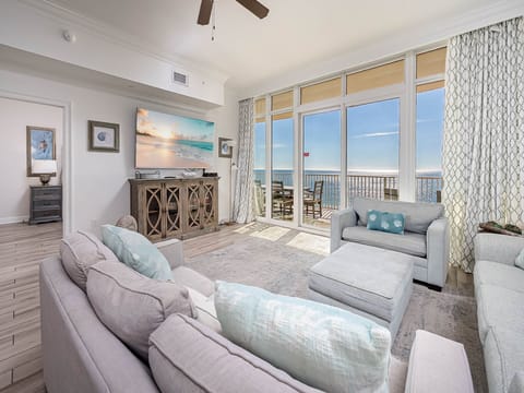 Sink into plush coastal seating while ocean waves sparkle beyond floor-to-ceiling windows—your private seaside sanctuary awaits.