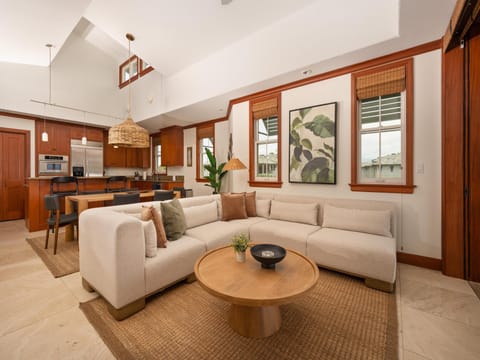Step into your bright, open-concept retreat with soaring ceilings, rich wood accents, and natural light pouring in. Sink into the plush sectional or gather in the adjoining kitchen—your perfect home base for unwinding after island adventures.