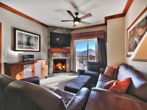 Cozy living room with convenient gas fireplace, flagstone hearth and mantle mounted flat screen TV